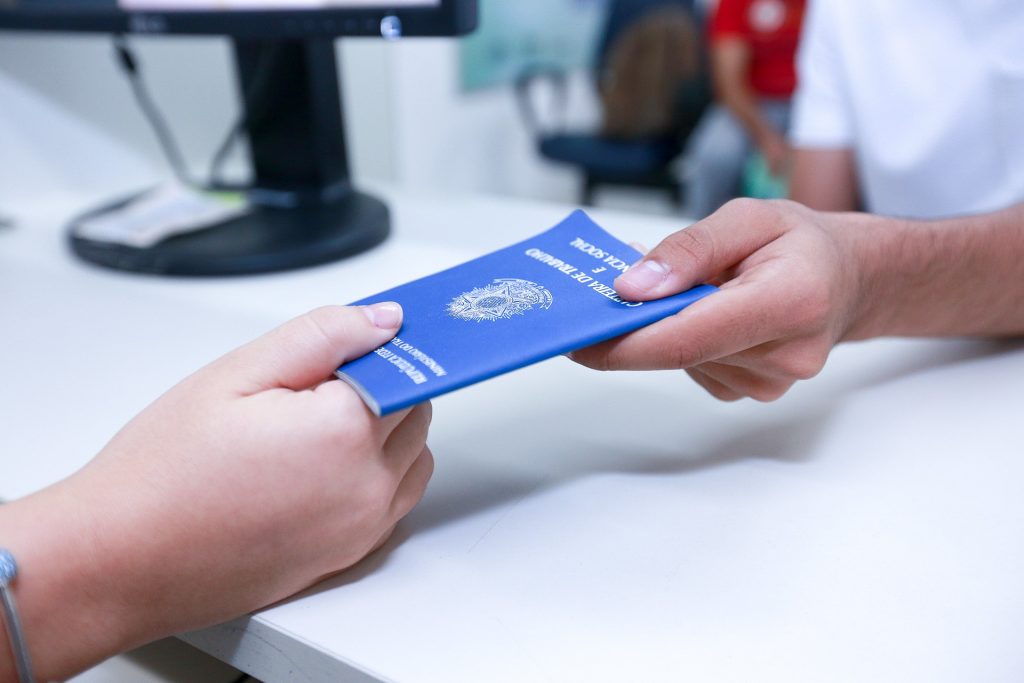 Carteira de trabalho sendo entregue a uma pessoa