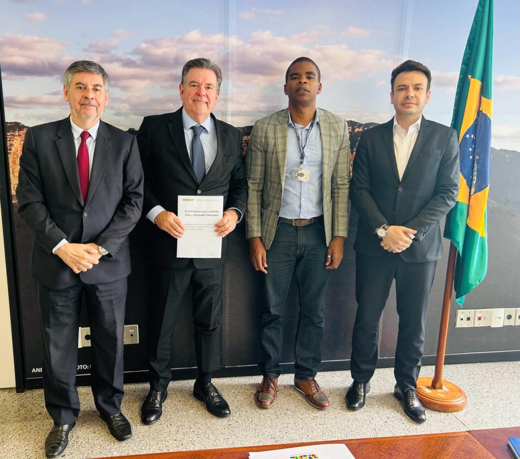 Quatro homens em pé com um quadro no fundo